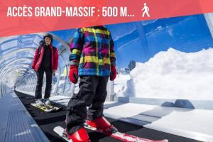 two people standing on skis under a sign at GREEN APPLE CARROZ Duplex WIFI Garage Balcon-Sud Vue Montagne in Les Carroz d'Araches
