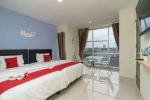 a bedroom with a large bed and a table at RedDoorz Plus near Eka Hospital BSD 5 in Tangerang