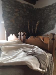 a bedroom with a bed with a stone wall at La Peiro Douco in Roure Turin