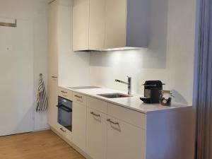 a white kitchen with a sink and a stove at Zentrum Lai 176 Hm Whg 103 Steibogg in Lenzerheide