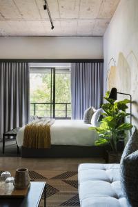 a bedroom with a bed and a large window at Blackbrick Sandton One in Johannesburg