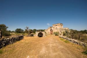 an old building on a dirt road with a bridge at Masseria Spina Resort in Monopoli