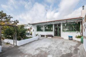 un edificio blanco con un banco en el patio en Finca Carrillo, en Lomo de Arico