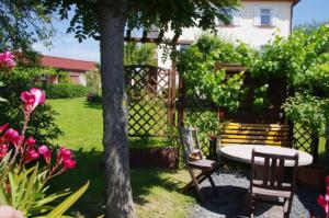 un jardín con mesa, sillas y una valla en Landhaus Blumenstein en Mülsen