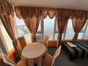 a room with a table and chairs and a large window at Family Hotel Paros in Pomorie