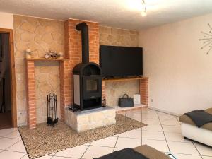 a living room with a brick fireplace with a tv at Ferienhaus am Hocheck in Oberaudorf
