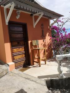 una casa con una puerta y una silla delante de ella en ti boukan trankil en La Montagne