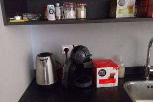 a kitchen counter with a tea kettle and a coffee maker at Huis bij de Catalpa in Dordrecht