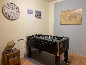 a room with a foosball table and a clock at Ferienwohnung Bornheim Hersel in Bornheim