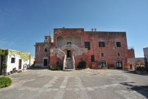 a large brick building with a staircase in front of it at Masseria Spina Resort in Monopoli