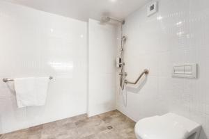 a white toilet sitting next to a shower in a bathroom at Campanile Toulouse Balma - Cité de l'Espace in Toulouse
