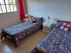 1 dormitorio con 2 camas y 2 mesas con lámparas en Terra Vista en Huerta Grande