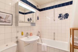 ein weißes Badezimmer mit Waschbecken und Badewanne in der Unterkunft Ferienwohnung Seeblick in Schilksee + 15 Fotos
