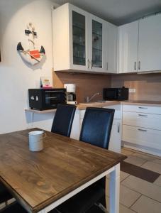a kitchen with a wooden table and blue chairs at Vier Jahreszeiten Haus 3 Whg 24 in Großenbrode