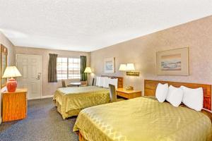 a hotel room with two beds and a desk at Days Inn by Wyndham Carson City in Carson City
