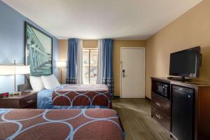 a hotel room with two beds and a flat screen tv at Super 8 by Wyndham Crestview in Crestview