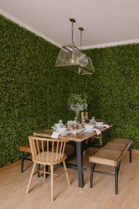 ein Esszimmer mit einem Tisch, Stühlen und einer grünen Wand in der Unterkunft Casa amigavel da Terra in Sesimbra