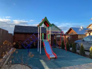 a playground with a slide in a yard at Вілла Джерело in Skhidnitsa