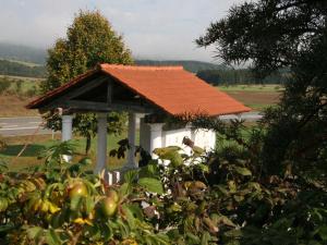 a gazebo with an orange roof next to a road at Ferienhaus Wilder Hunsrück 