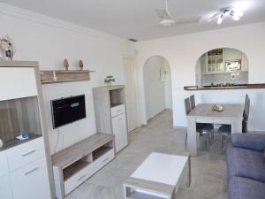 a living room and kitchen with a couch and a table at GOLF Y MAR - Oliva Nova in Oliva