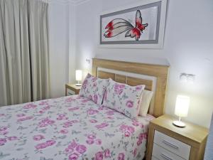 a bedroom with a bed with pink flowers on it at GOLF Y MAR - Oliva Nova in Oliva +45 photos