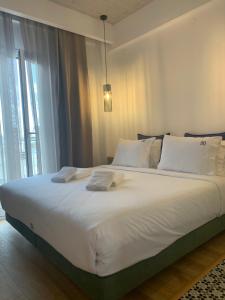 a large white bed in a room with a window at White Bottle Superior Apartments in Thessaloniki