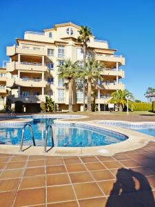 a hotel with a swimming pool in front of a building at GOLF Y MAR - Oliva Nova in Oliva