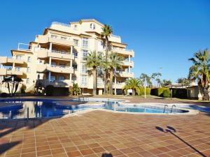 a building with a swimming pool in front of a building at GOLF Y MAR - Oliva Nova in Oliva