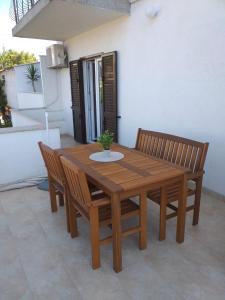een houten tafel met twee stoelen en een tafel met een plant bij Apartmani Tina in Jelsa