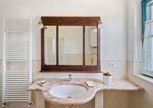 La salle de bains est pourvue d'un lavabo et d'un miroir. dans l'établissement Agriturismo San Giuseppe, à Volterra