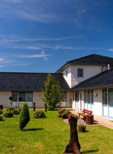 une grande maison avec une cour dotée d'une pelouse sidx sidx sidx dans l'établissement TOP Motel Sassnitz, à Lanken