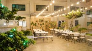 a restaurant with tables and chairs and plants at Kuei Ti Wan Hotel in Checheng