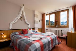 una camera da letto con un letto con cuscini sopra di Animae Natura Hotel & Chalet a Mezzana