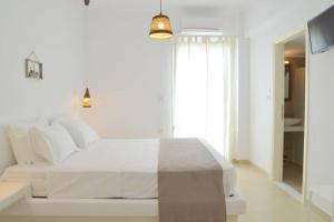 a white bedroom with a white bed and a window at Casa Mare Pollonia in Pollonia