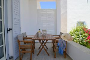 a patio with a wooden table and chairs on a balcony at Casa Mare Pollonia in Pollonia