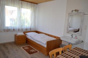 a bedroom with a bed and a sink and a mirror at Landgasthaus Krone in St. Johann in Sankt Johann