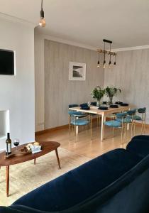a living room with a blue couch and a table at Casa amigavel do Mar in Sesimbra