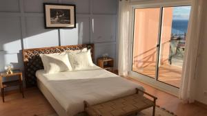 a bedroom with a bed and a large window at Casa amigavel do Mar in Sesimbra