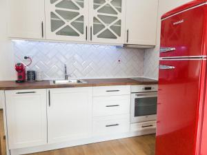 una nevera roja en una cocina con armarios blancos en Stylish loft studio with great view to Ardino, en Ardino