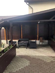 a patio with a bench and a table and chairs at Holiday Luxury Villa with private Garden in Şelimbăr