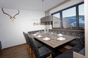 a dining room with a wooden table and chairs at Gut Stein Panoramalodge in Mühlbach am Hochkönig