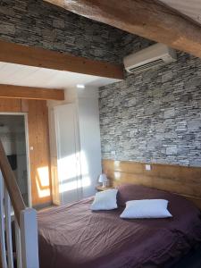 - une chambre avec un lit et un mur en pierre dans l'établissement Chambres d'Hôtes Pom' Paille, à Pupillin