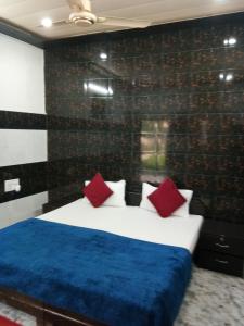 ブリンダーバンにあるRadha Krishna Dhamのベッドルーム1室(赤と青のシーツが備わるベッド1台付)