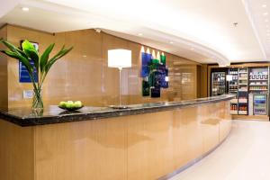 a lobby with a bar with a vase of fruit on the counter at Holiday Inn Express Rosario, an IHG Hotel in Rosario