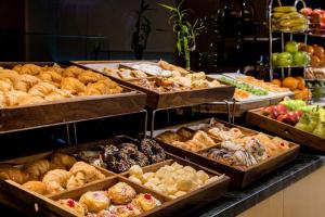 a bakery with many different types of pastries in trays at Holiday Inn Express Rosario, an IHG Hotel in Rosario