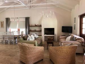 a living room with couches and a television and a table at Frog Mountain Getaway in Swellendam