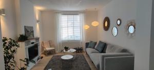 a living room with a couch and a tv at Kanne: charming house between nature and shopping in Kanne