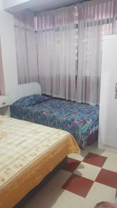 a room with two beds and a window with curtains at Residencial Hinojosa in Oruro