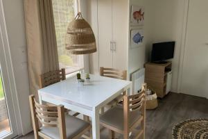 a dining room with a white table and chairs at Chalet in Renesse in Renesse