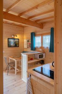 Cabaña de madera con cocina y mesa en Les Lodges de la ViaRhôna / cabane-spa, en Virignin